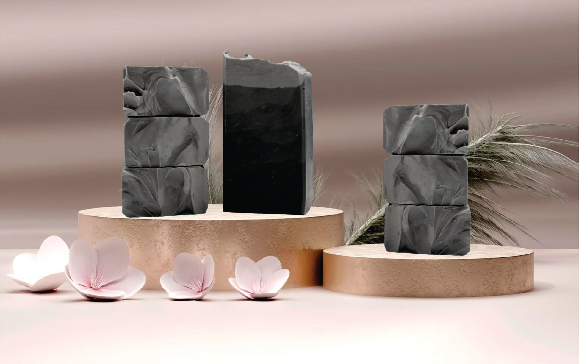 Green marbled soap bars on wooden stands with pink flowers and leaves.